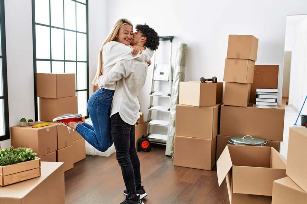 Couple happily hugging in a room with boxes